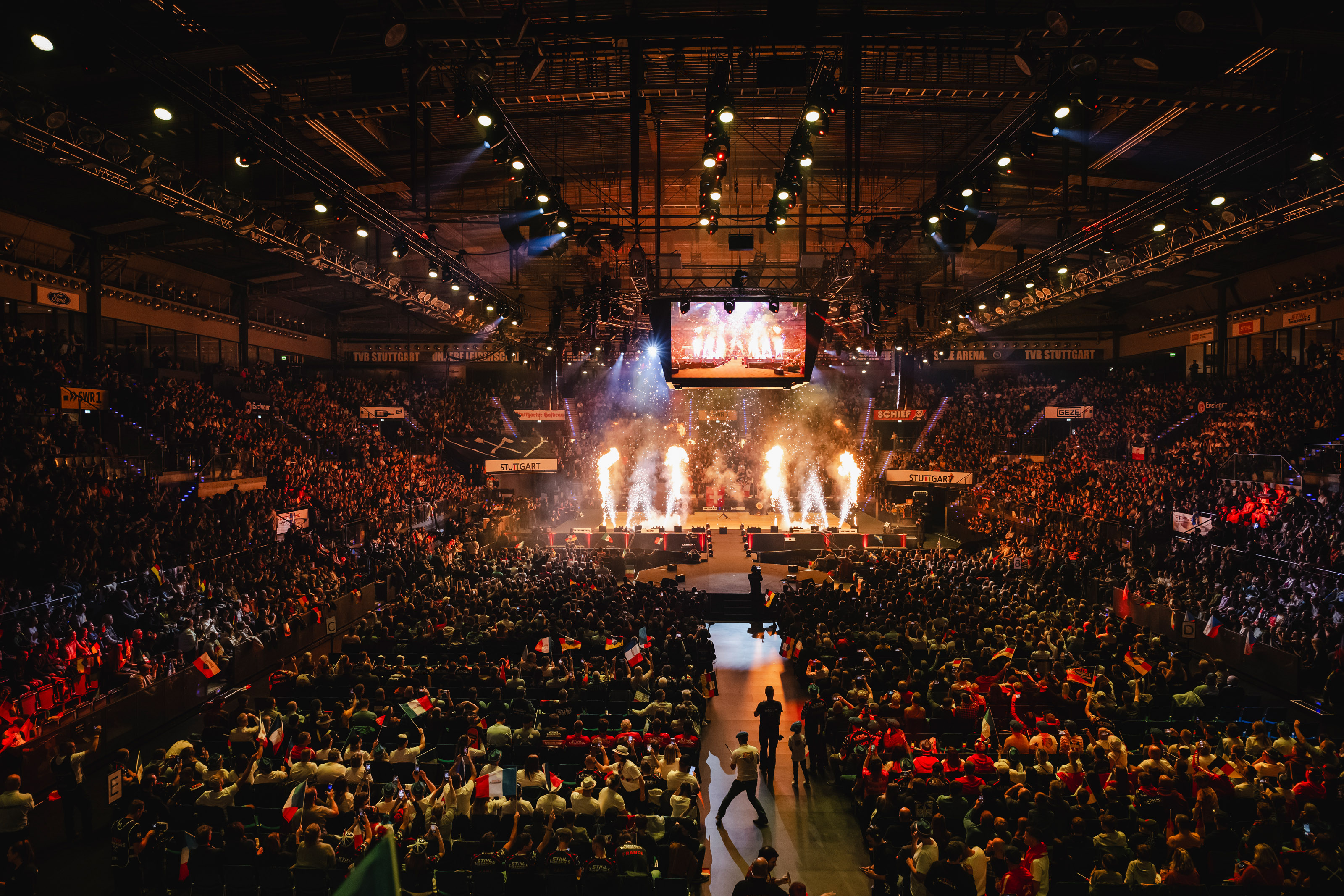 TIMBERSPORTS® event arena with firework on stage and spectators in the foreground