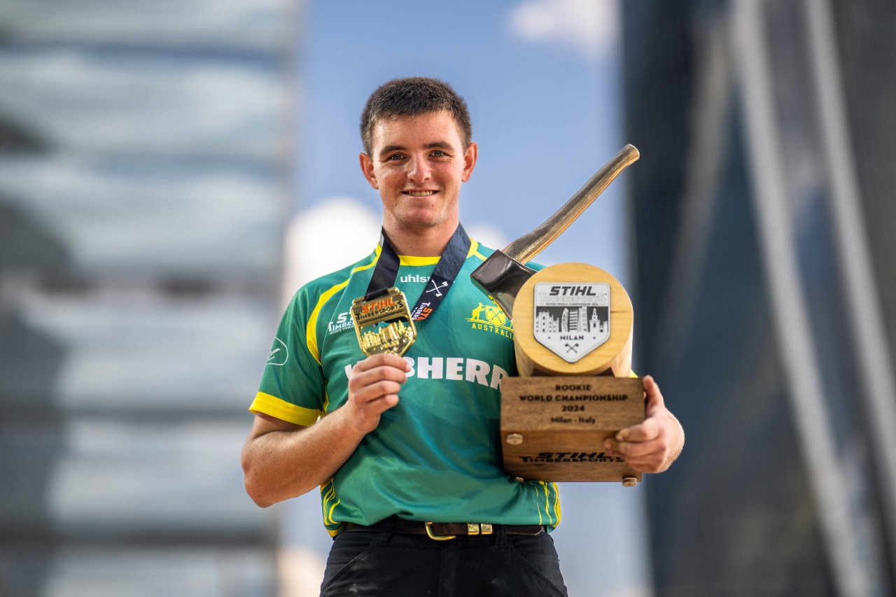Französischer TIMBERSPORTS® Athlet auf Podium mit Trophäe